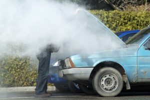 ManLookingAtASmokingEngineInHisCar - Meineke Chicago Blown Head Gasket | Meineke Car Care | Naperville, IL